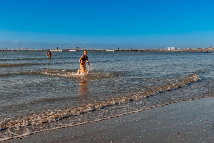 женщина бежит из моря