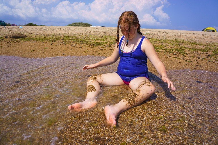 Девочка купается в море